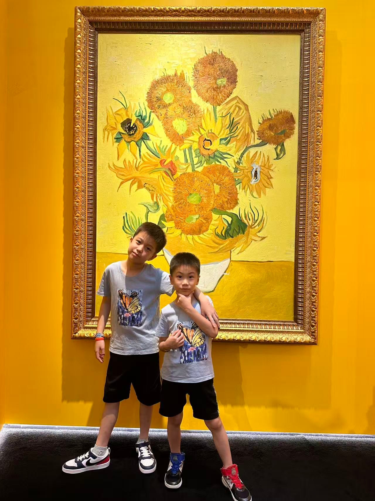 兩兄弟穿蝴蝶 T-shirt 在梵高向日葵畫前