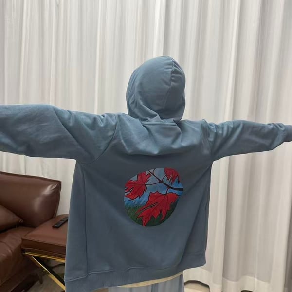 穿著帽衫背面展示楓葉圓形圖案